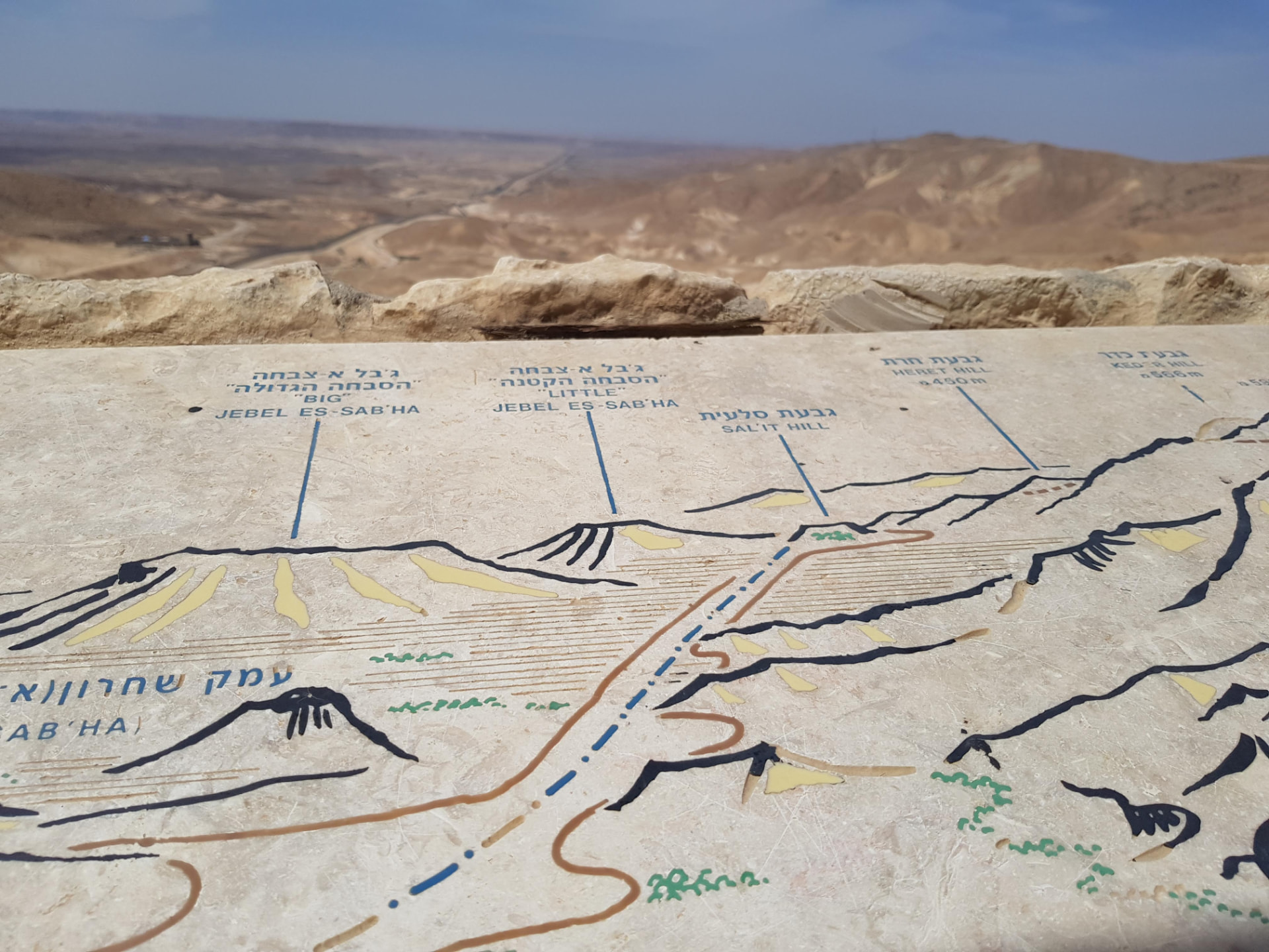 שלט אבן מידעני בתצפית מדברית, ממפה את רכסי ההרים והעמקים שבאופק